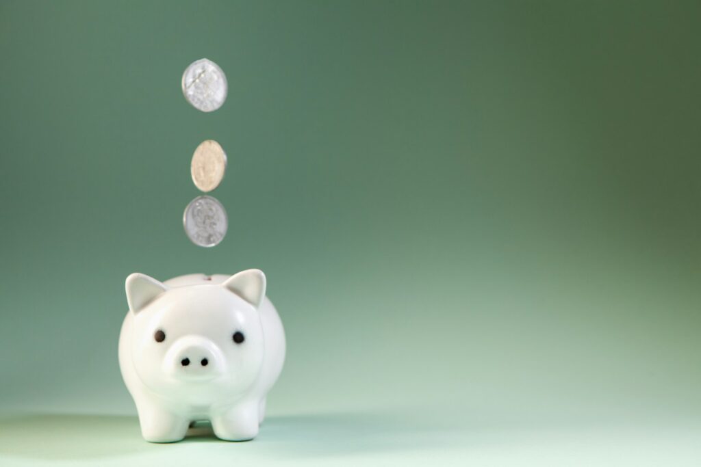 貯金箱に落ちるコイン(年金・老後の備えのイメージ)