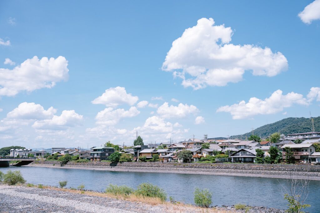 青空の下の日本の町並みと川(日本国内に残る財産のイメージ)